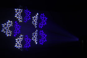 Lila och vita blomformade ljusmönster projicerade på vägg av en moving head-lampa – skapar en elegant och dynamisk ljuseffekt för scen eller fest.